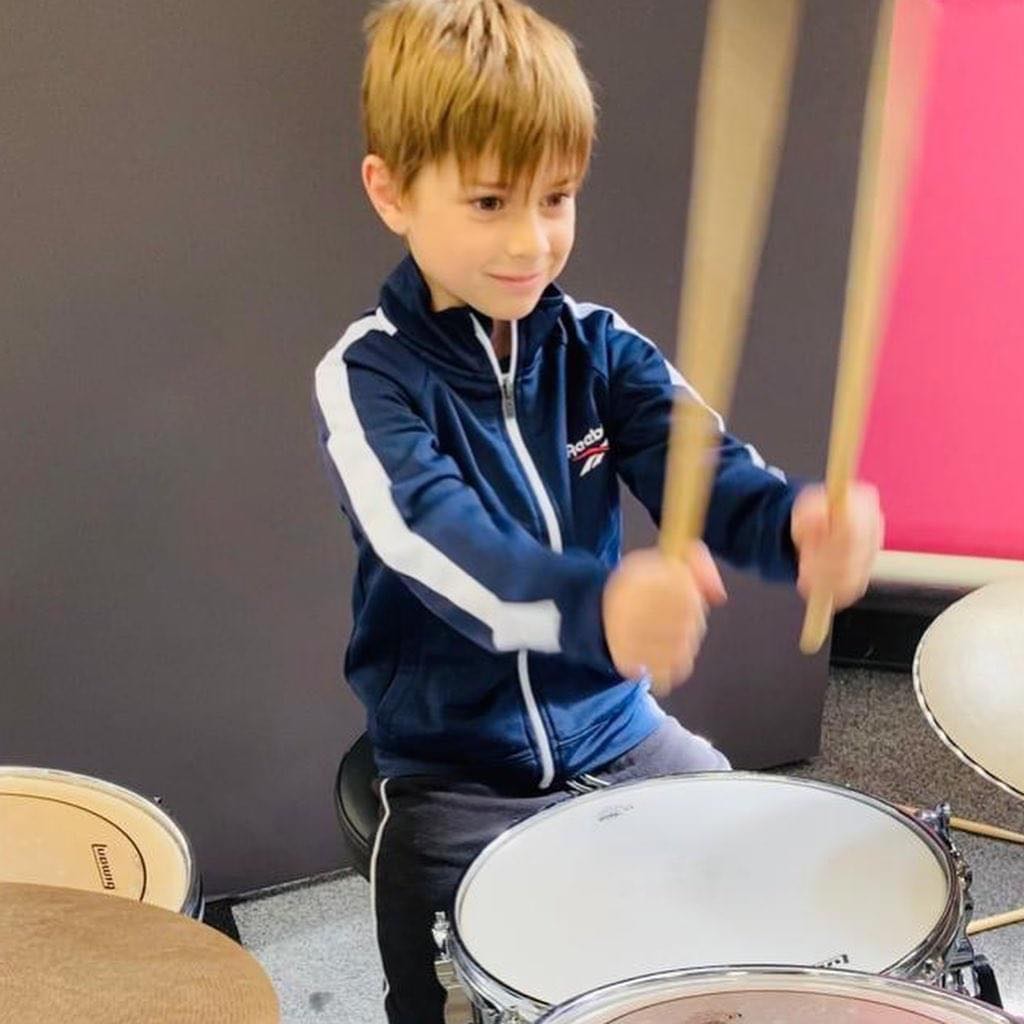 A child plays the drums for the LS18 Rocks project