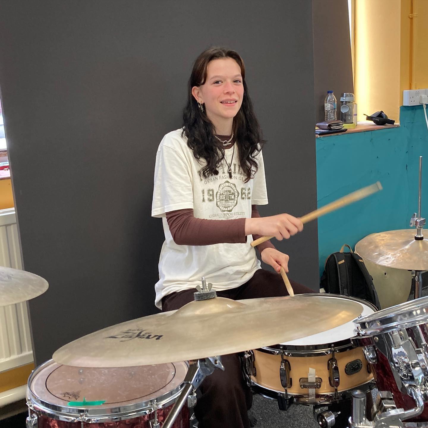 A teenager plays the drums for the LS18 Rocks project