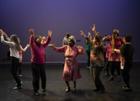 Elderly people dancing on a stage, an example for age-friendly arts offers.