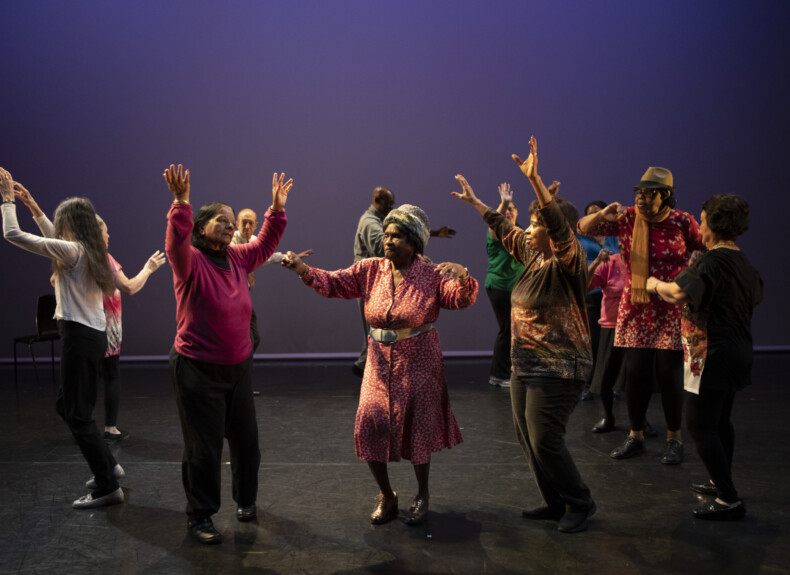 Elderly people dancing on a stage, an example for age-friendly arts offers.