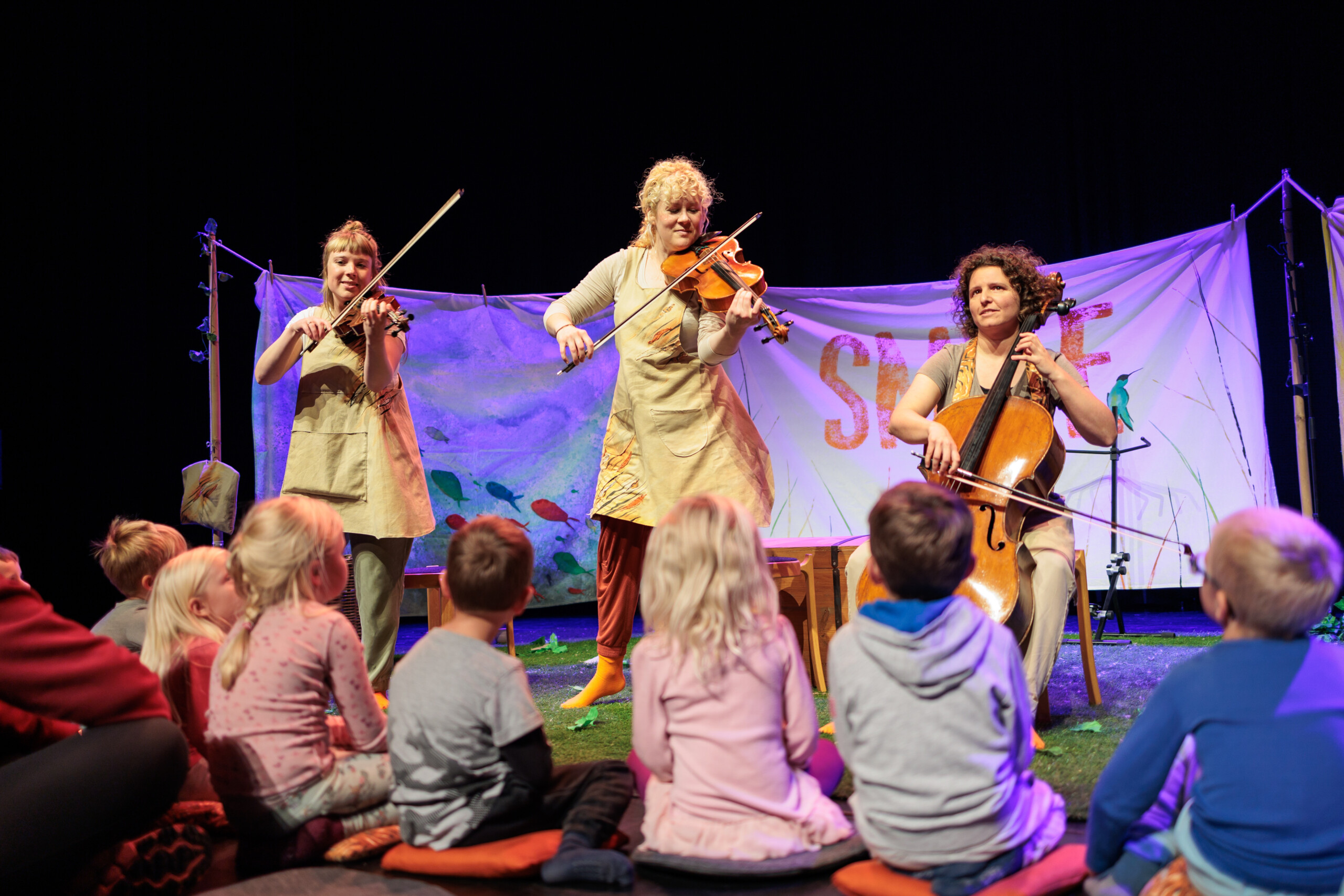 Musicians play to an audience of young children